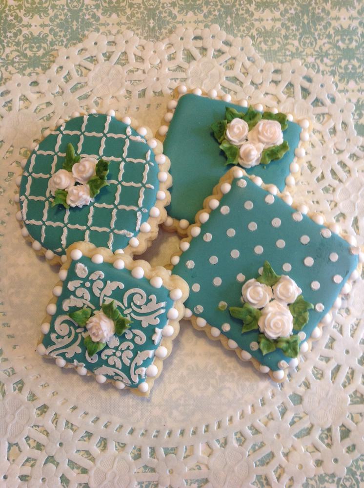 White roses on teal cookies